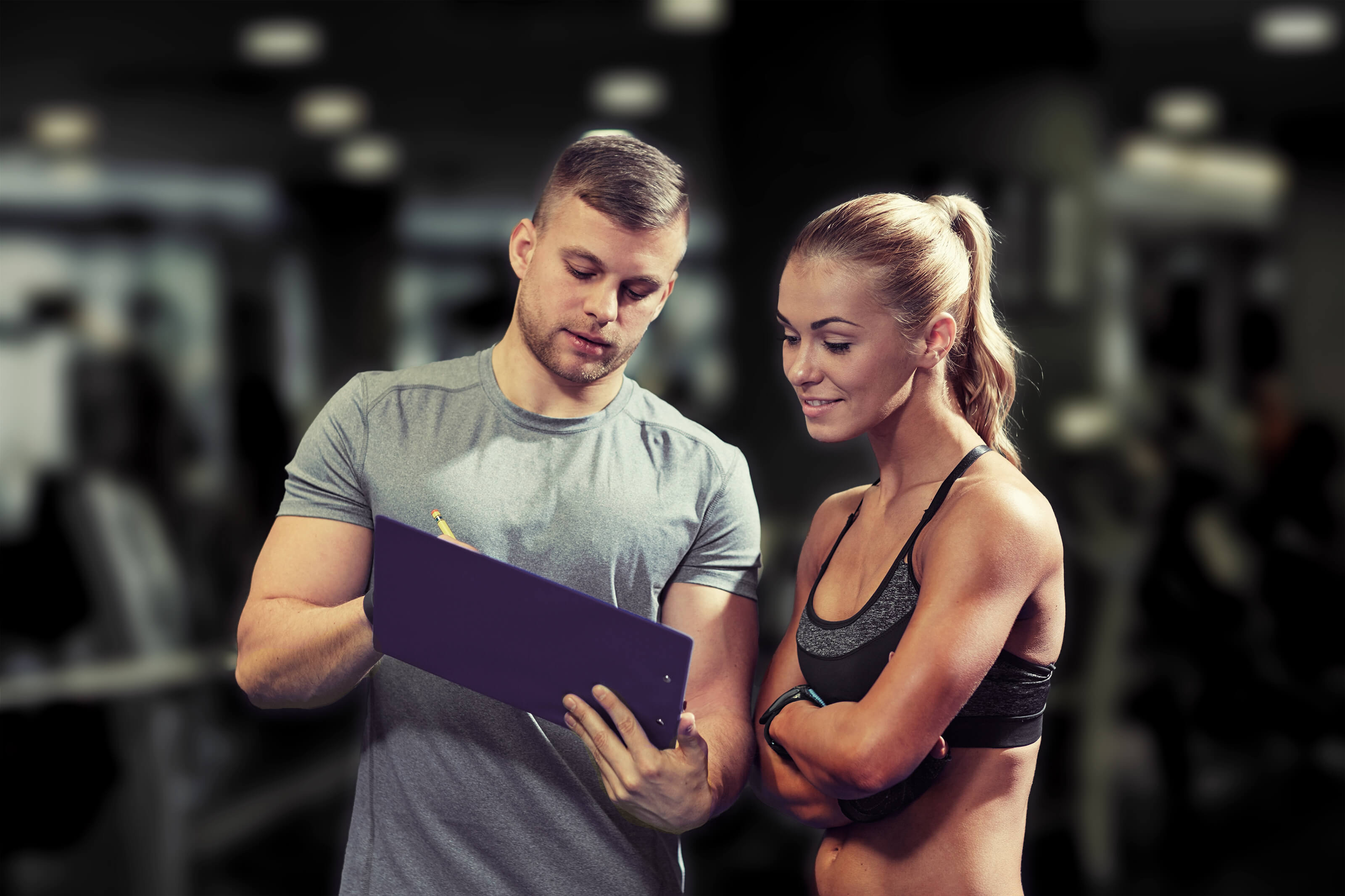 A gym trainer and client looking at phone